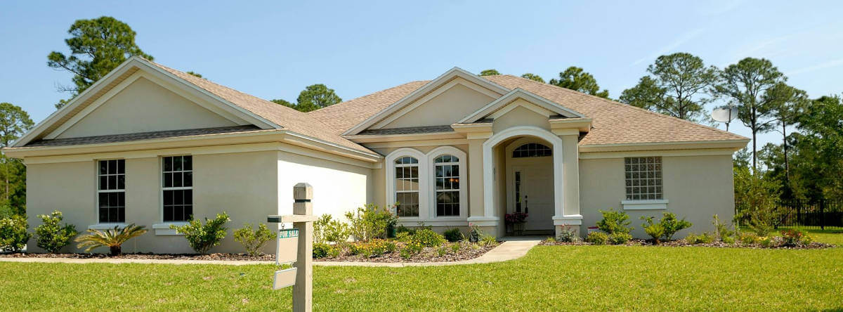 A beautiful suburban house featuring a well-maintained lawn and landscaping.