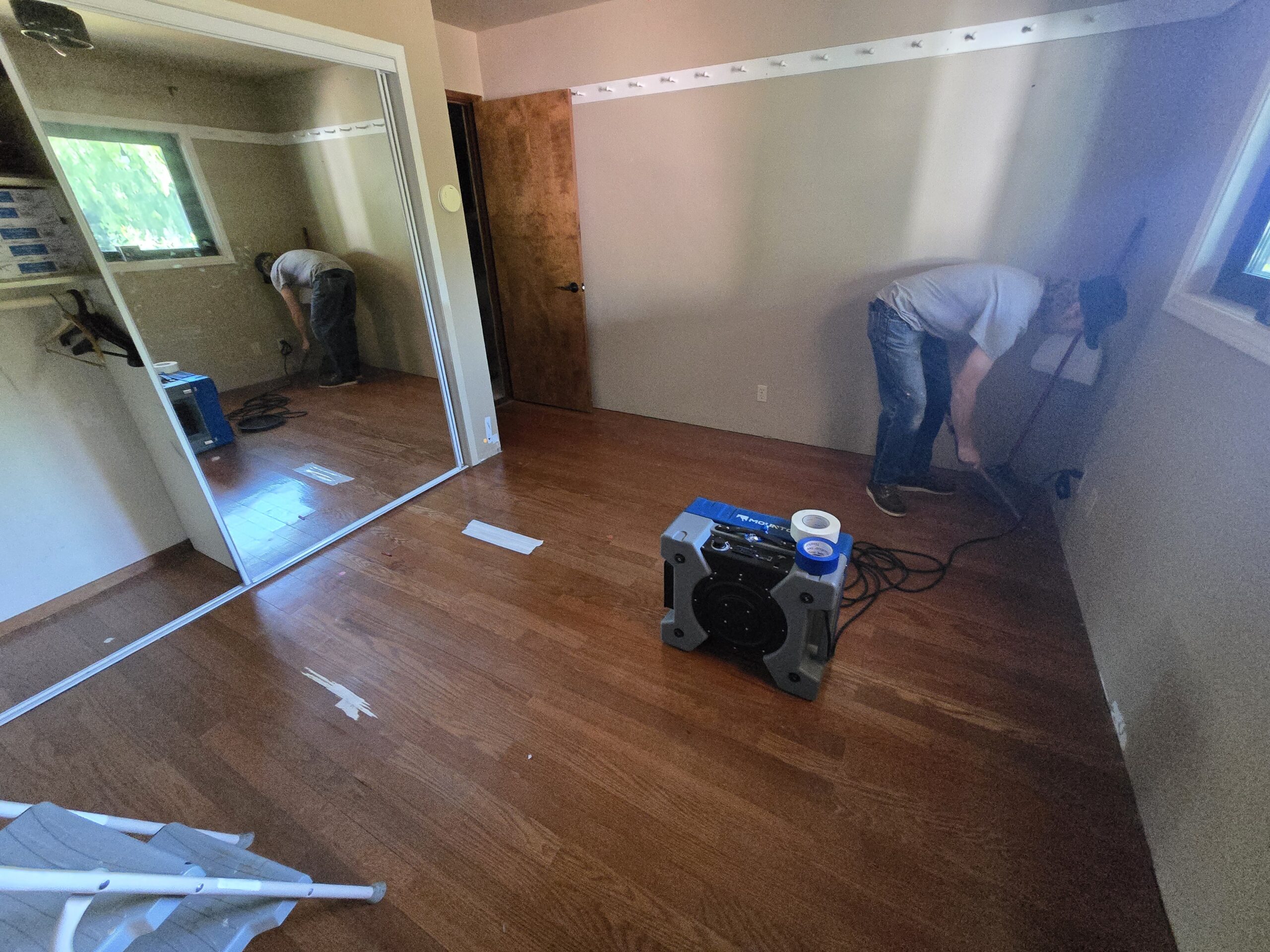 a man setting up a machine to dry out a room with water damage